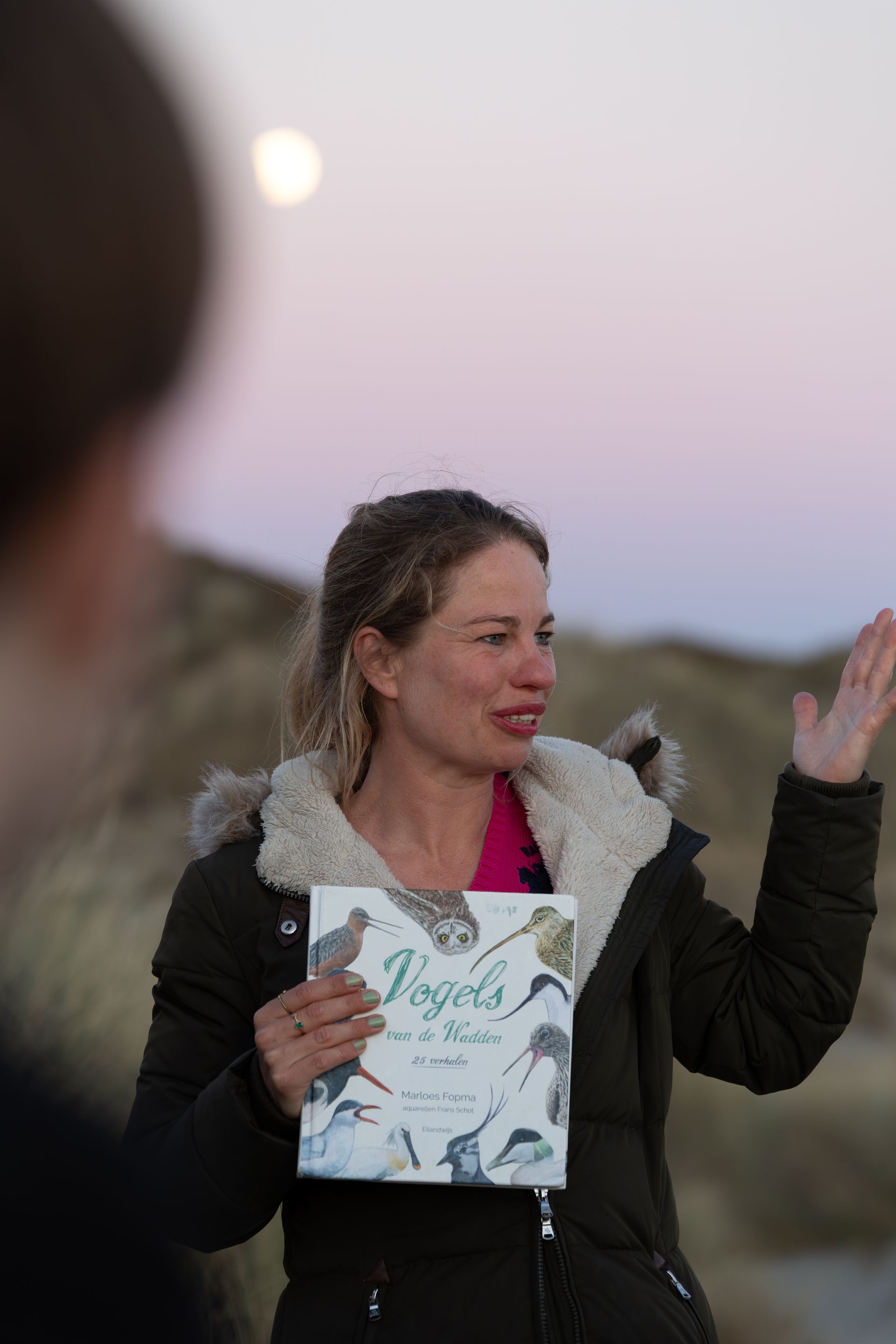 Eilandmeisje met vogelboek bij volle maan in de schemering