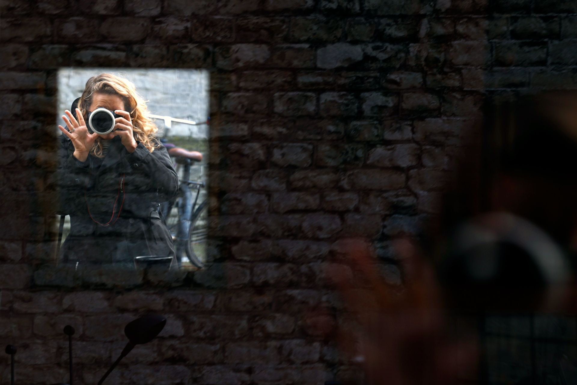 Zelfportret van Jennifer Klinkenberg-Weber met camera, weerspiegeld in een raam